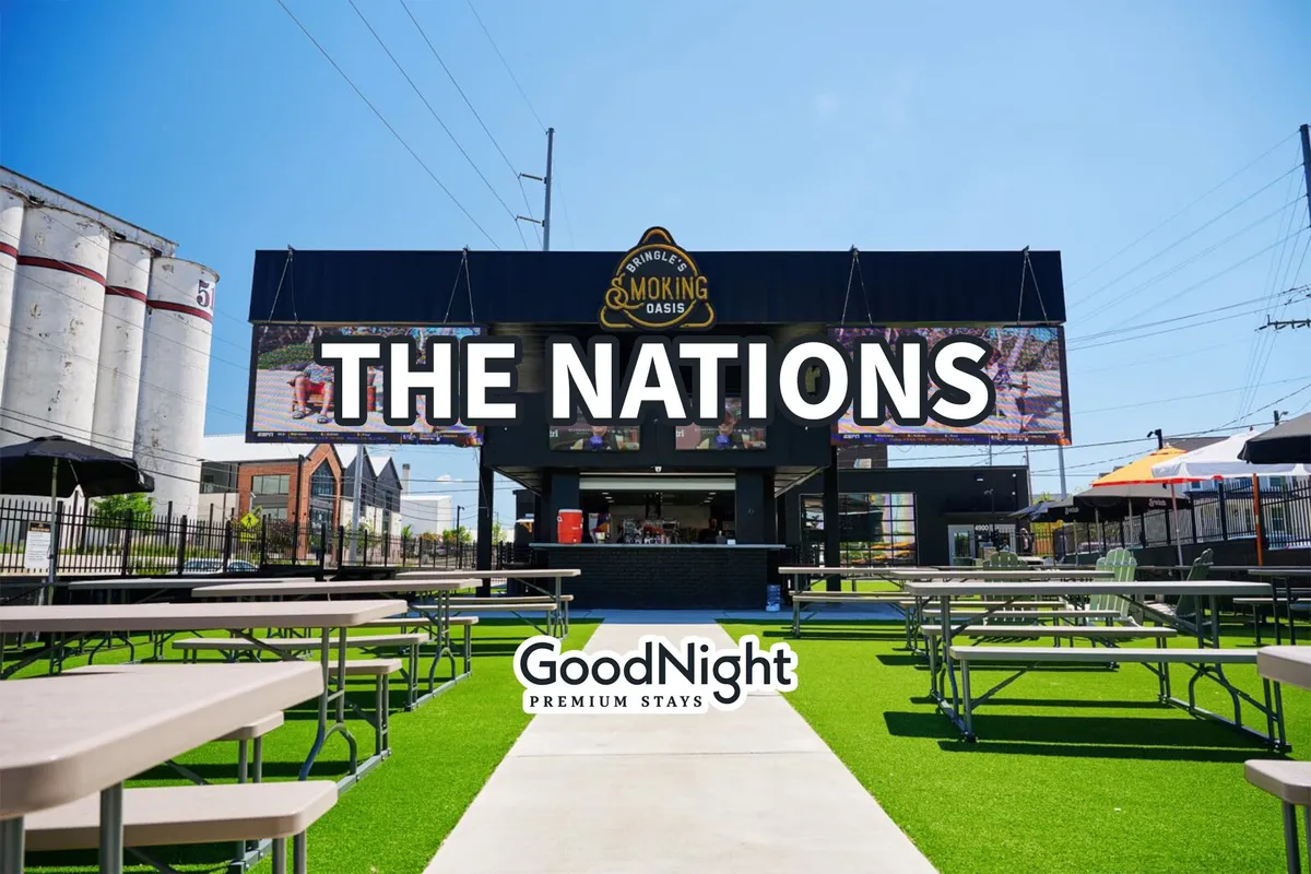 A lively exterior shot of 'THE NATIONS' sign, set over a bustling outdoor dining area with tables and people enjoying meals. The food service counter and communal seating convey a sense of neighborhood energy and culinary creativity.
