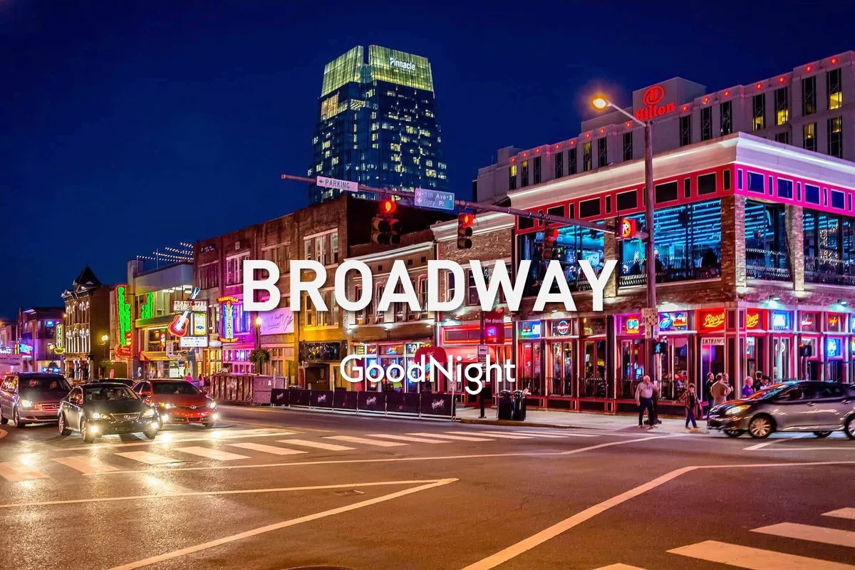 A lively nighttime street scene in Nashville, illuminated by bright neon signs and bustling with people enjoying the energetic nightlife. Tall buildings frame the vibrant street filled with locals and visitors experiencing the pulse of the city's famous music and entertainment district.